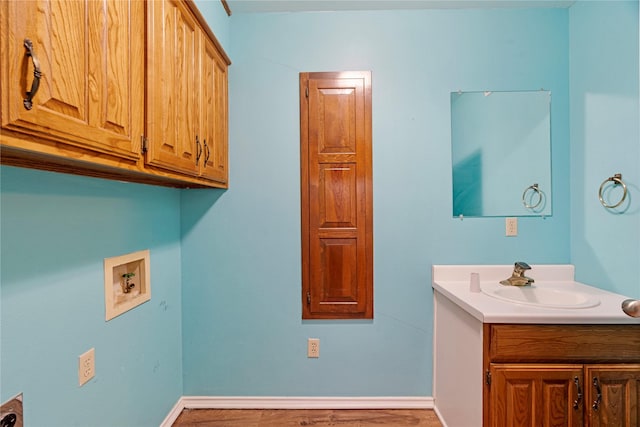 laundry room with washer hookup, a sink, cabinet space, and baseboards