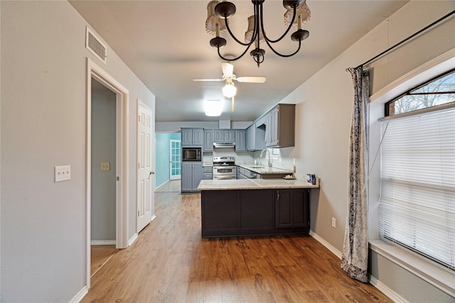 kitchen with stainless steel electric range oven, light wood-style floors, a peninsula, built in microwave, and under cabinet range hood