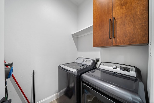 laundry area with cabinets and washing machine and clothes dryer