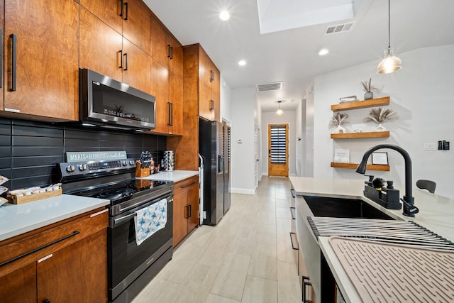 kitchen featuring pendant lighting, decorative backsplash, sink, and stainless steel appliances