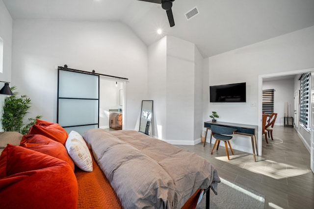 bedroom featuring ceiling fan, a barn door, and lofted ceiling