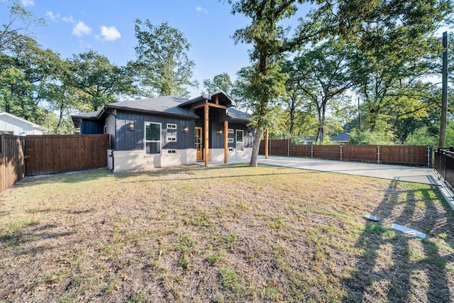 rear view of house featuring a lawn and a patio area