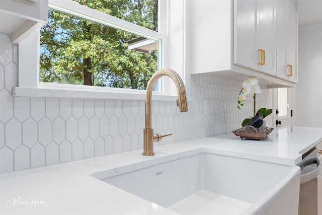 251 Jessie Jones Dr, Benton, LA 71006 - room details with decorative backsplash, a sink, white cabinetry, and light stone counters