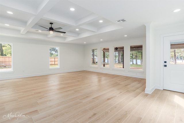 unfurnished living room featuring beamed ceiling, a healthy amount of sunlight, light hardwood / wood-style flooring, and coffered ceiling