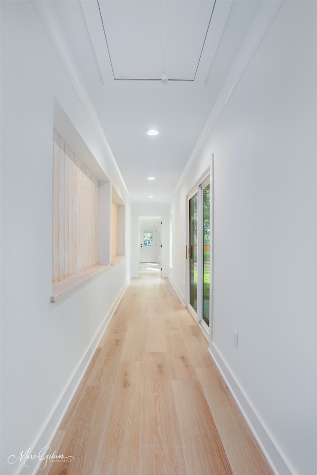 hallway with ornamental molding and light wood-type flooring