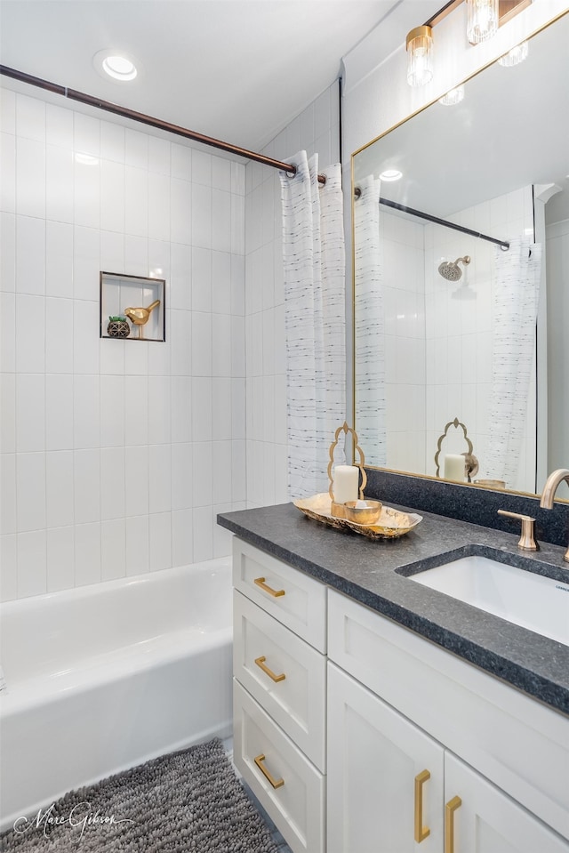 bathroom with tile patterned flooring, vanity, and tiled shower / bath