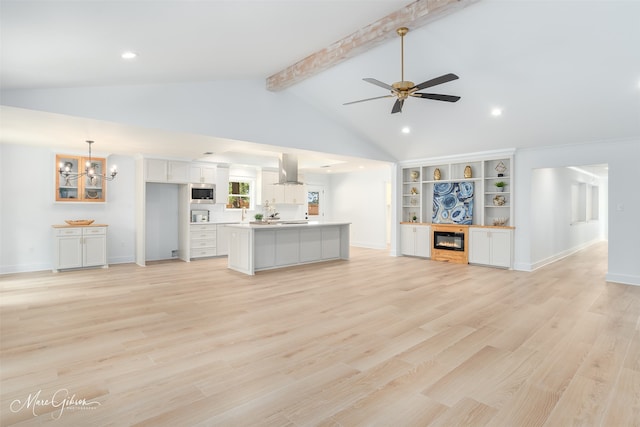 unfurnished living room featuring beam ceiling, ceiling fan with notable chandelier, high vaulted ceiling, and light hardwood / wood-style flooring