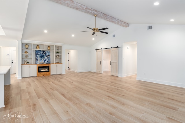 251 Jessie Jones Dr, Benton, LA 71006 - unfurnished living room featuring a barn door, a ceiling fan, vaulted ceiling with beams, light wood-style floors, and visible vents