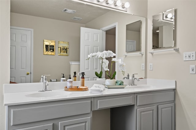 full bathroom with visible vents, a sink, and double vanity