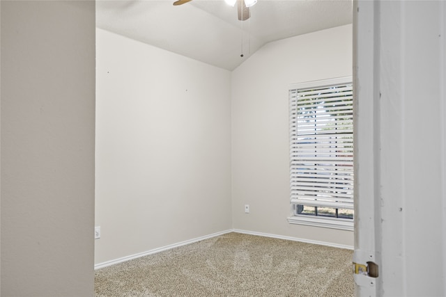 carpeted spare room featuring vaulted ceiling, baseboards, and ceiling fan