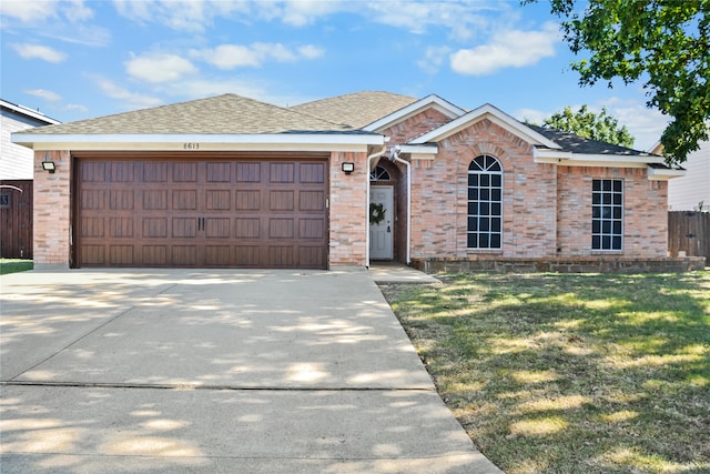 single story home with a garage and a front lawn