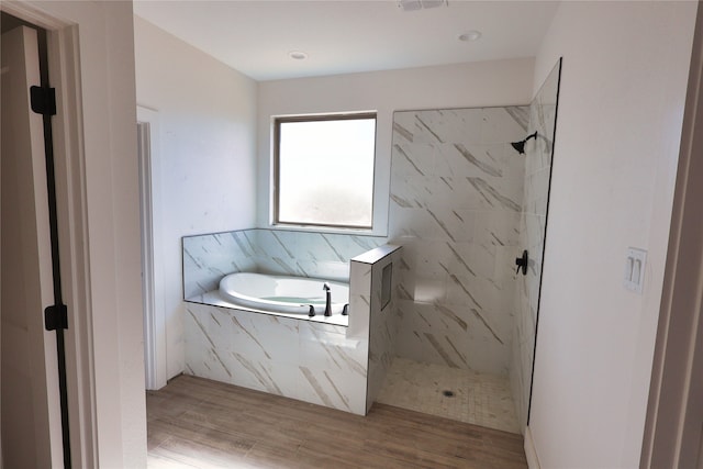 bathroom featuring wood-type flooring and separate shower and tub