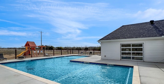 view of swimming pool with a patio and a playground