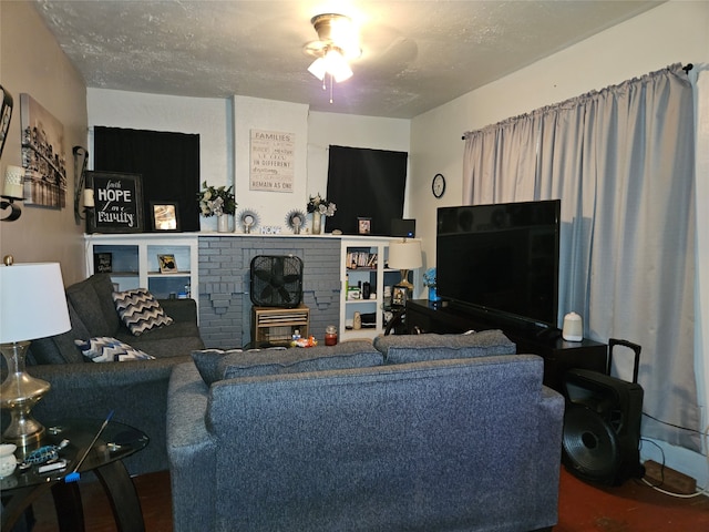 living room with a textured ceiling and ceiling fan