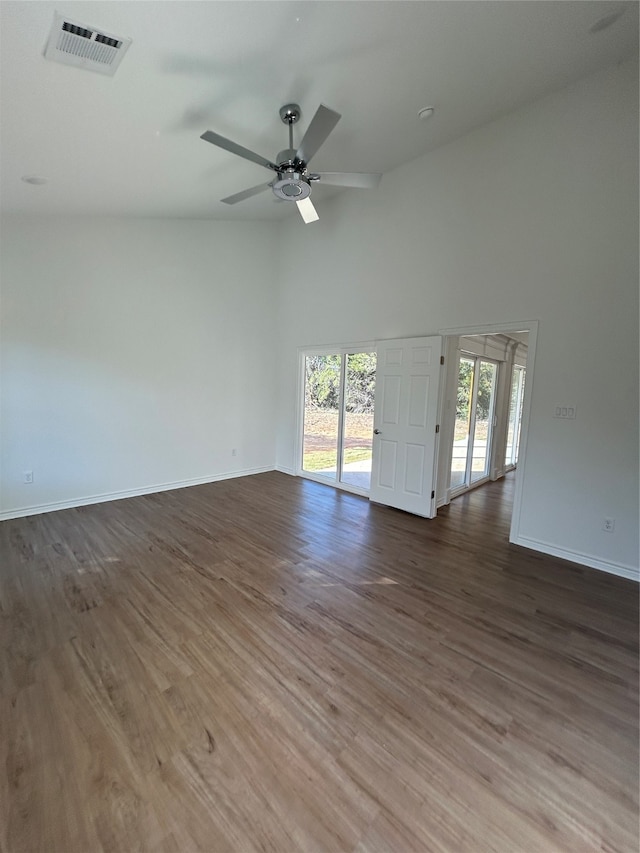 empty room with dark hardwood / wood-style floors, ceiling fan, and high vaulted ceiling