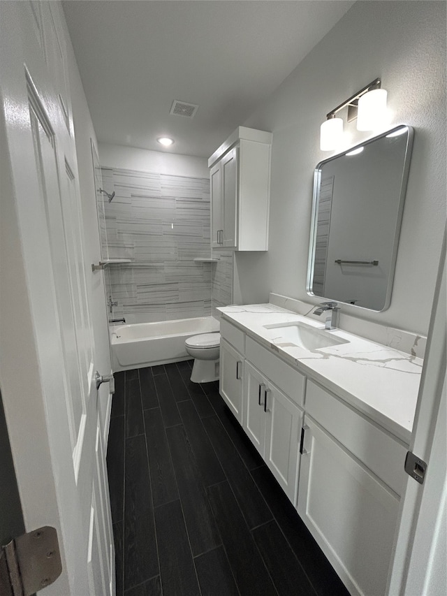 full bathroom featuring wood-type flooring, vanity, toilet, and tiled shower / bath combo