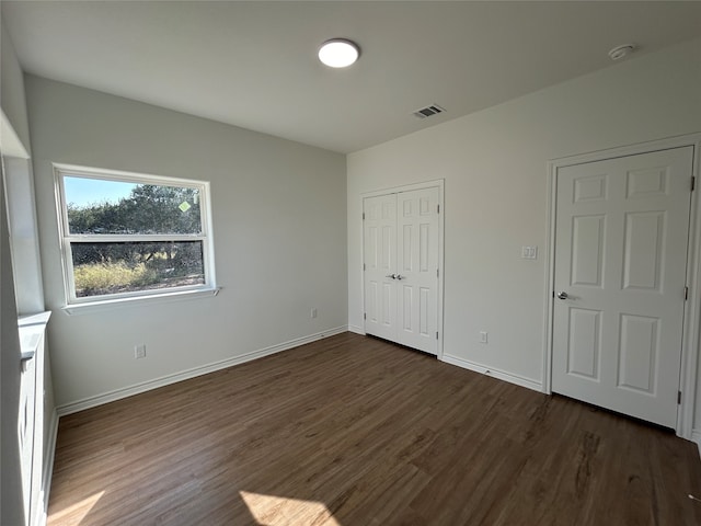 unfurnished bedroom with dark hardwood / wood-style flooring