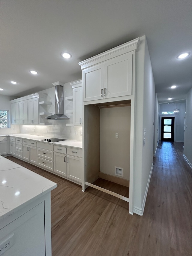 kitchen featuring backsplash, dark wood-type flooring, white cabinets, wall chimney exhaust hood, and black electric cooktop