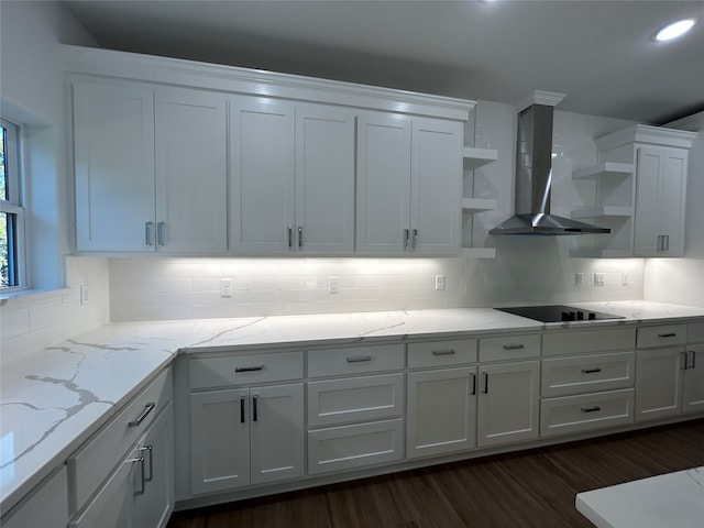 kitchen featuring white cabinetry, dark wood-type flooring, wall chimney range hood, decorative backsplash, and black electric stovetop