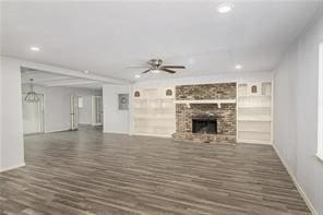 unfurnished living room featuring a brick fireplace, dark hardwood / wood-style floors, and ceiling fan