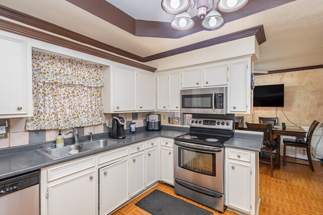 kitchen with sink, white cabinets, stainless steel appliances, and light parquet flooring