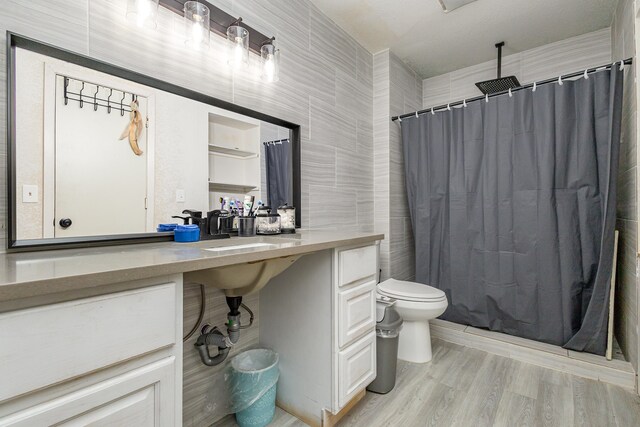 bathroom with toilet, hardwood / wood-style floors, a shower with curtain, and vanity