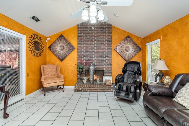 tiled living room with vaulted ceiling, a fireplace, and ceiling fan