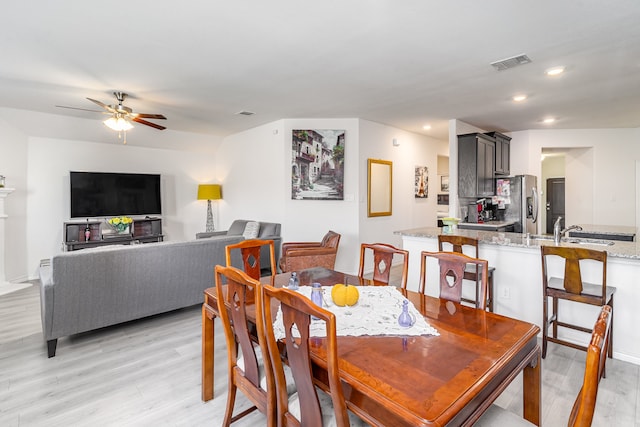 dining area with ceiling fan and light hardwood / wood-style floors