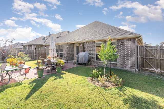 rear view of house featuring a yard and a patio area