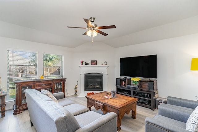 living room with vaulted ceiling, ceiling fan, and light wood-type flooring