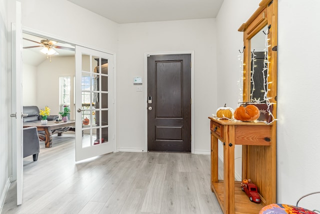 foyer with french doors, ceiling fan, vaulted ceiling, and light hardwood / wood-style flooring