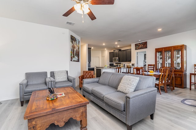 living room with ceiling fan and light hardwood / wood-style floors