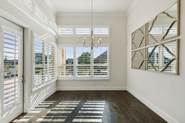 unfurnished dining area featuring dark wood-type flooring, ornamental molding, and a chandelier