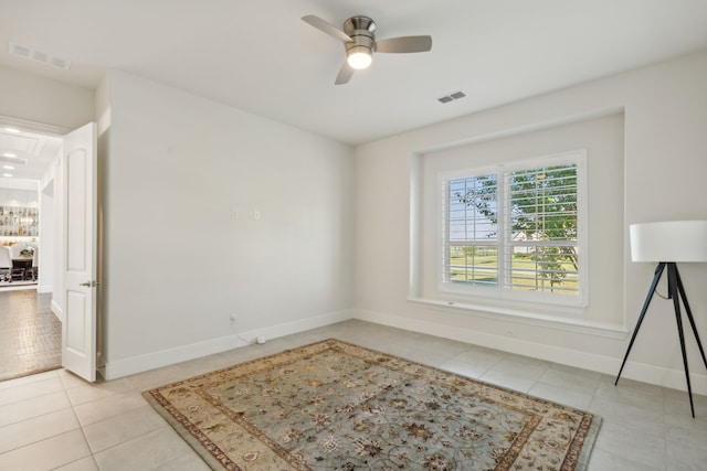 empty room with light tile patterned flooring and ceiling fan