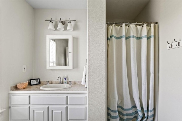bathroom featuring a shower with shower curtain and vanity