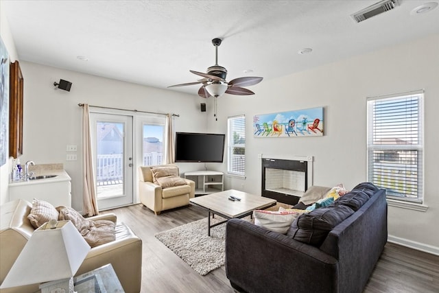 living room with french doors, hardwood / wood-style flooring, a healthy amount of sunlight, and ceiling fan