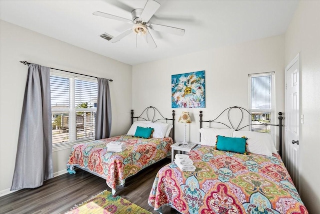bedroom with baseboards, ceiling fan, wood finished floors, and visible vents