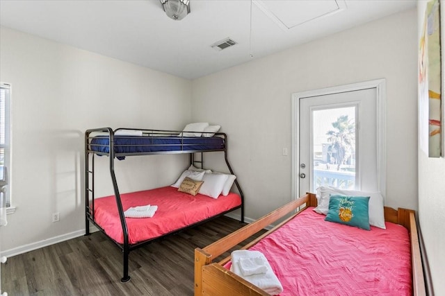 bedroom featuring baseboards, visible vents, and wood finished floors