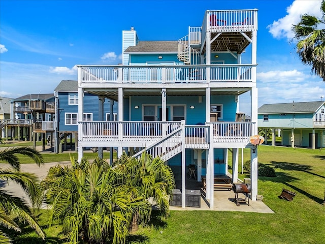 back of house featuring a patio area, a deck, and a lawn