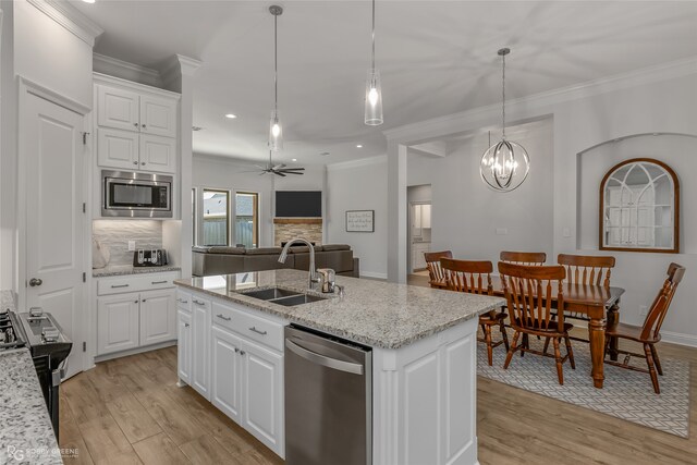 kitchen with sink, an island with sink, white cabinets, and appliances with stainless steel finishes