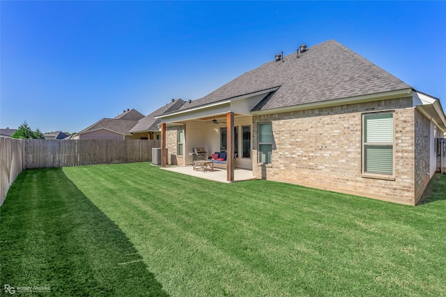 back of property with ceiling fan, central AC unit, a patio area, and a lawn