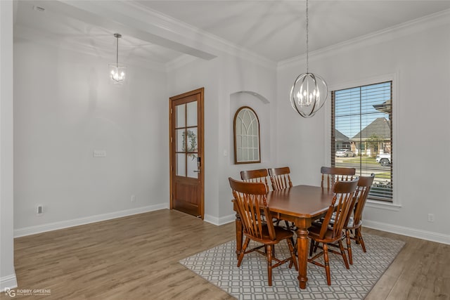 dining space featuring ornamental molding, light hardwood / wood-style flooring, and a notable chandelier