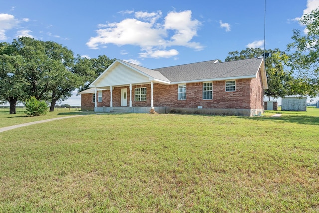 single story home with a storage shed and a front lawn