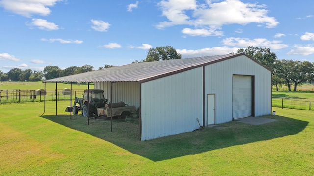 view of outbuilding with a rural view and a lawn