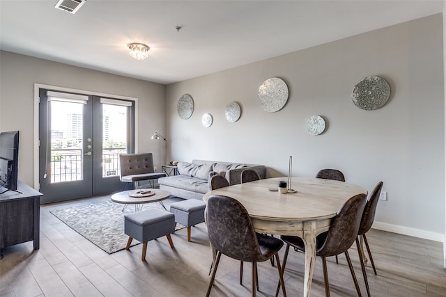 dining space featuring french doors and light wood-type flooring