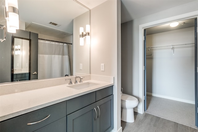 bathroom featuring vanity, hardwood / wood-style flooring, and toilet