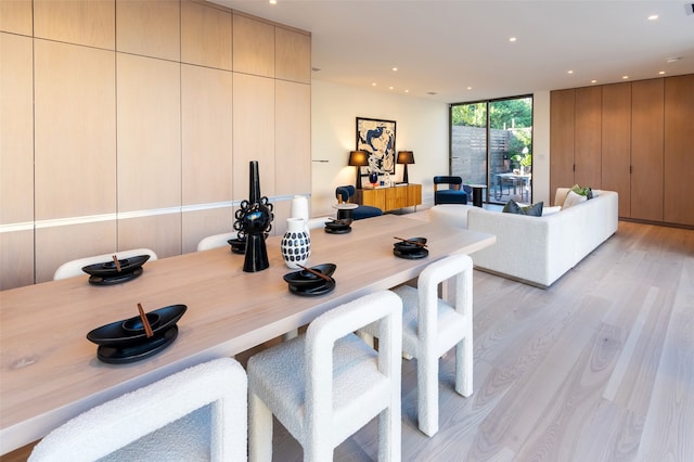 dining space with expansive windows and light wood-type flooring