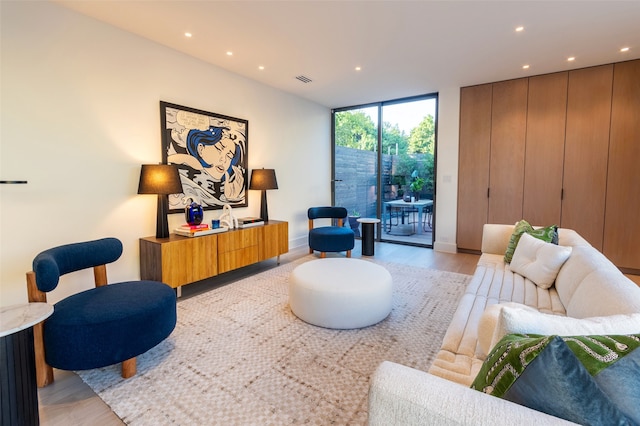 sitting room with expansive windows and light wood-type flooring