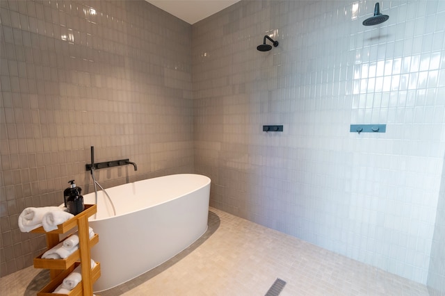 bathroom with tile patterned floors, tile walls, and separate shower and tub