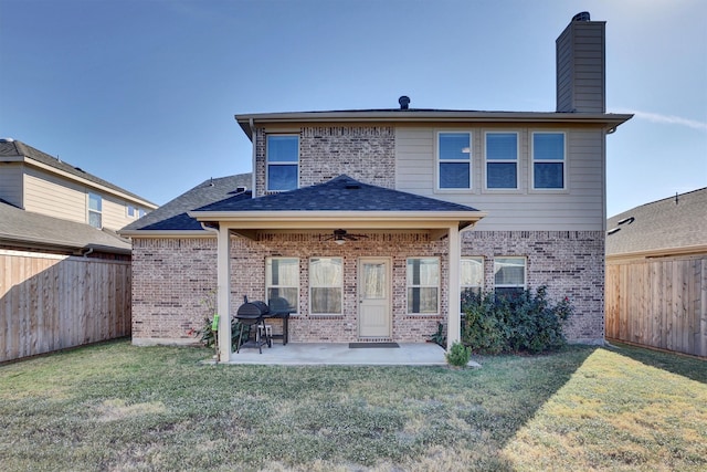 rear view of property with ceiling fan, a lawn, and a patio area